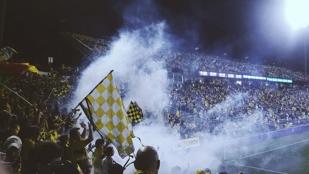 Stadiontribune med fans og gule flag